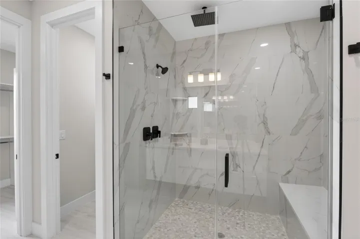 OVERSIZED PRIMARY BATHROOM features a spacious WALK-IN SHOWER with built-in bench for a luxurious spa-like experience!