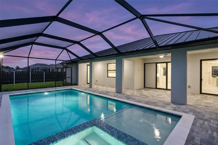 This CONTEMPORARY LUXURY HOME features SCREENED, HEATED POOL & SPA