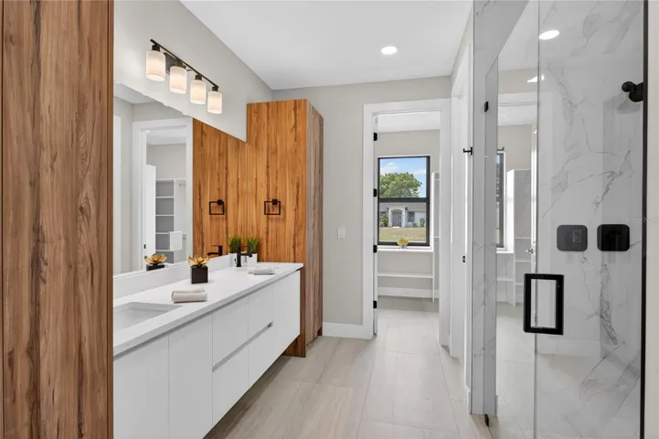 LUXURIOUS PRIMARY BATHROOM w/ spacious WALK-IN GLASS SHOWER w/ floor-to-ceiling designer tile, rainfall showerhead, built-in bench & modern matte-black fixtures.