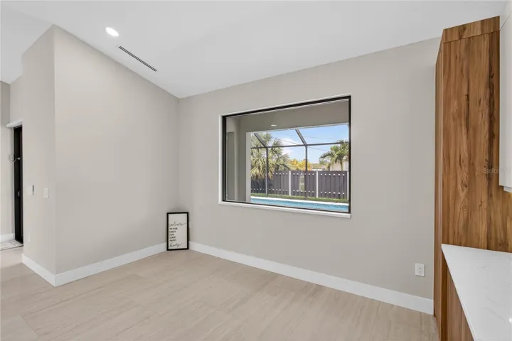 LARGE PICTURE WINDOW brings in natural light & offers views of screened lanai & pool/spa.