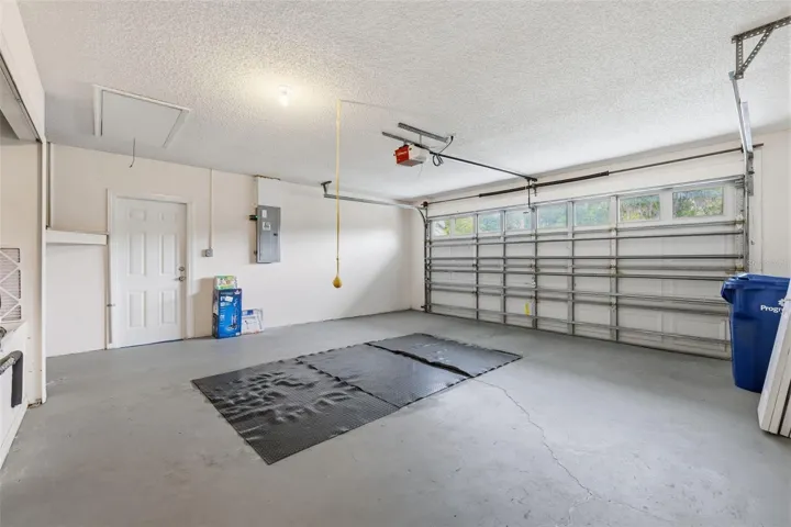 Clean two-car garage with side entry door from outside and automatic garage door opener. Surge protector on electrical panel.