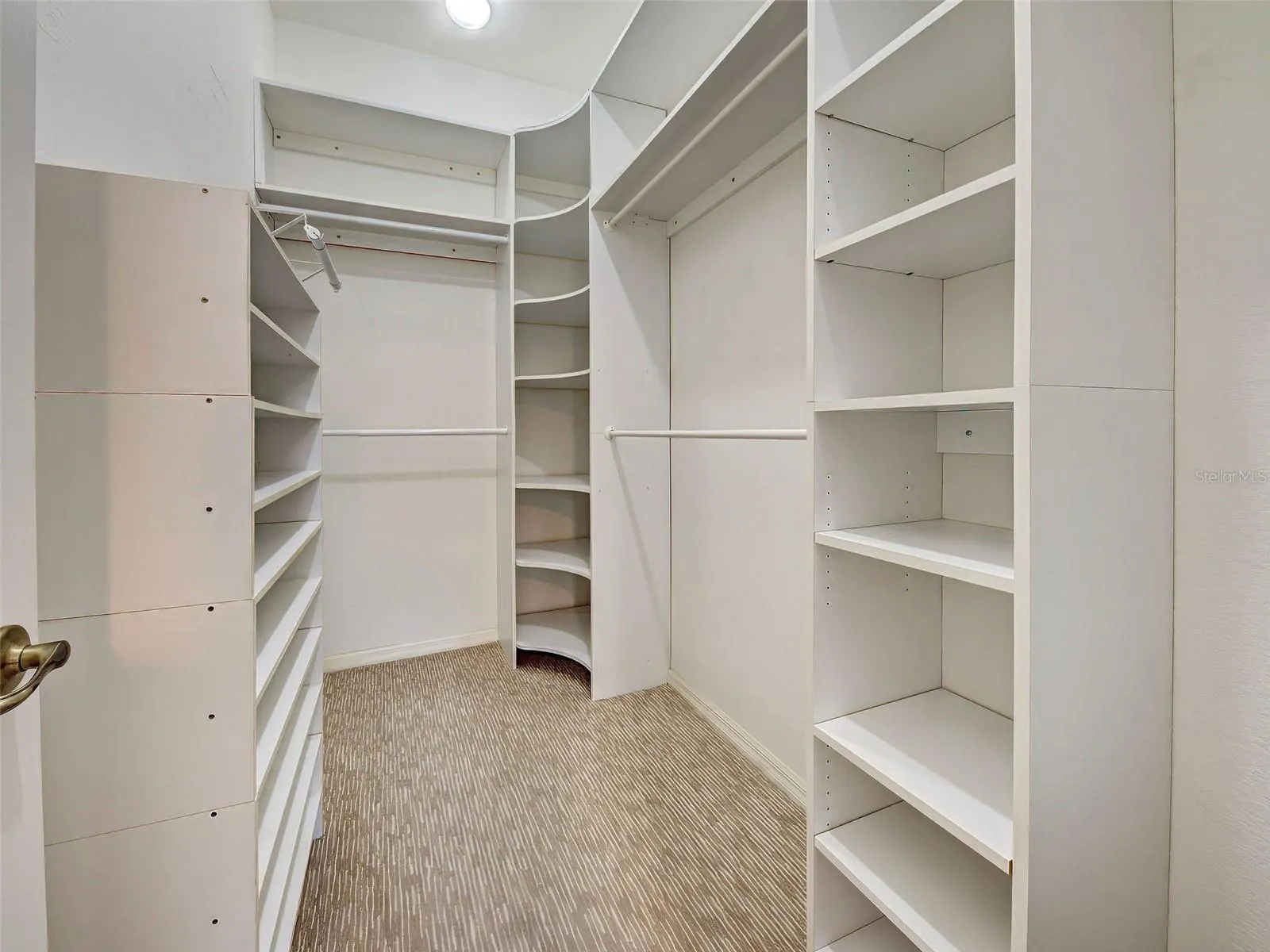 There are hanging bars and shelves in the walk-in closet.