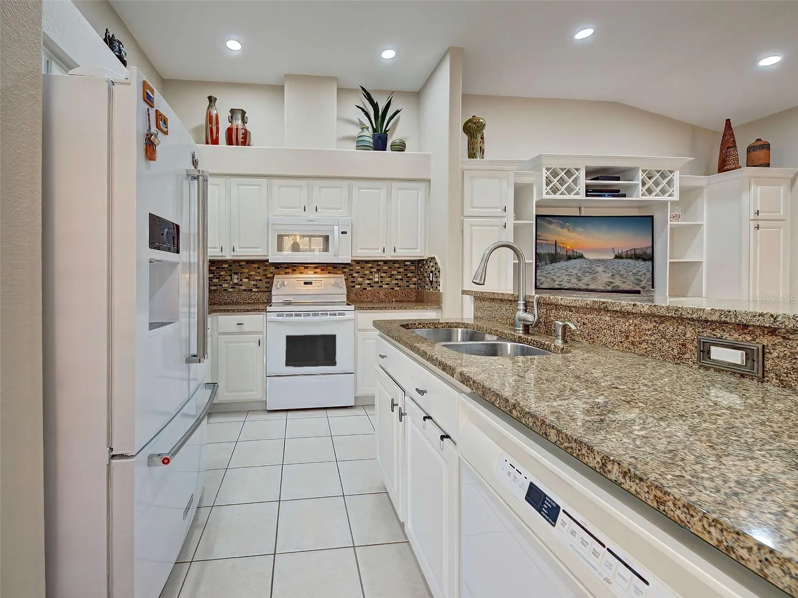 The kitchen opens up the den/flex room, with built in cabinets with space for a TV and wine cubbies on top.