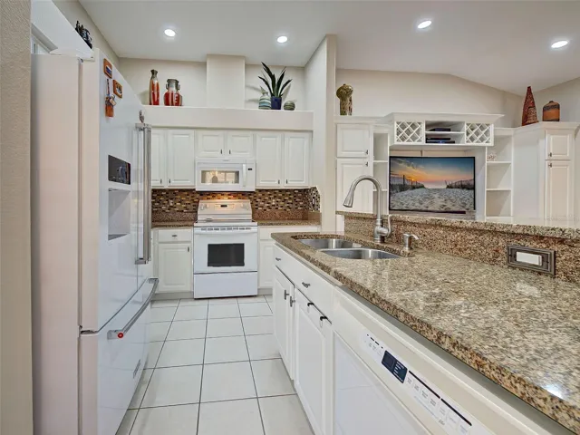 The kitchen opens up the den/flex room, with built in cabinets with space for a TV and wine cubbies on top.