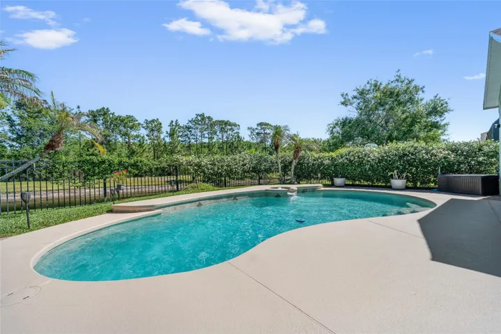 pool with beasutiful jasmine and black cast iron fence