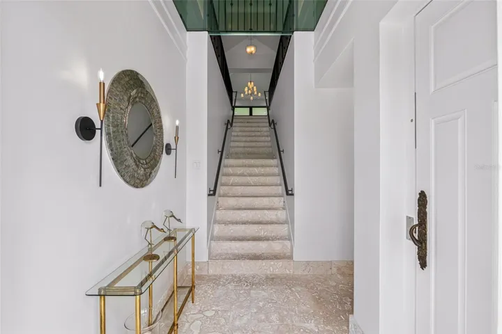 Welcome in! Dramatic Coral Stone Entry Foyer with Custom Metal & Glass Door