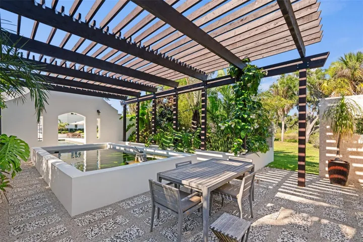 Enchanting Coral Stone Koi Garden with Trellised Dining Retreat