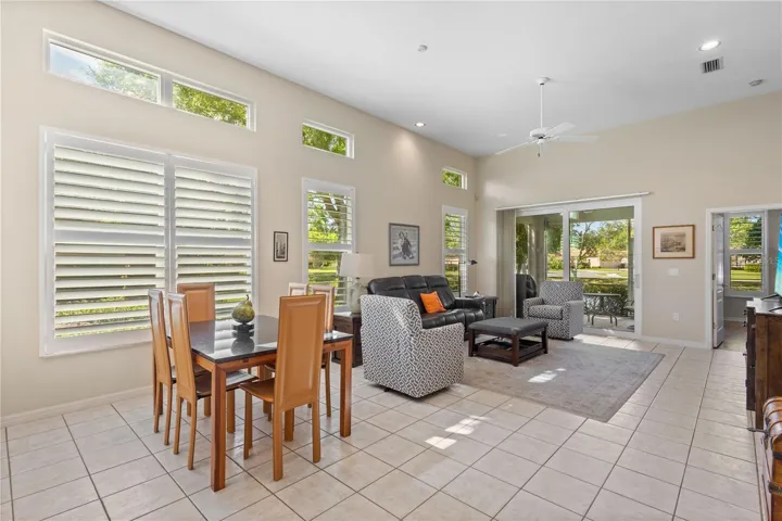 Light-filled Great room with soaring ceilings, plantation shutters, and expansive, impact sliding glass doors and windows
