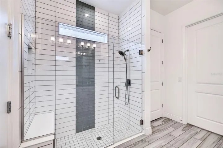 Glass-enclosed shower with upgraded tile