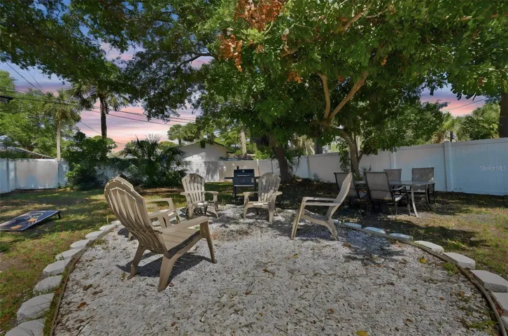 Huge spacious backyard with firepit area and shaded trees