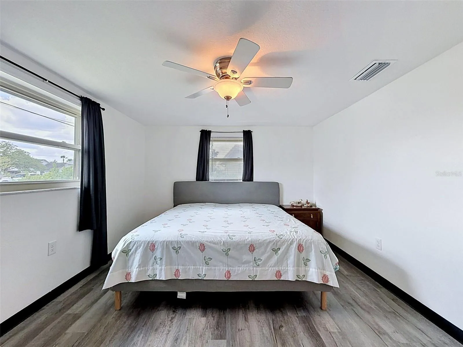 Spacious guest bedroom with abundant natural light.