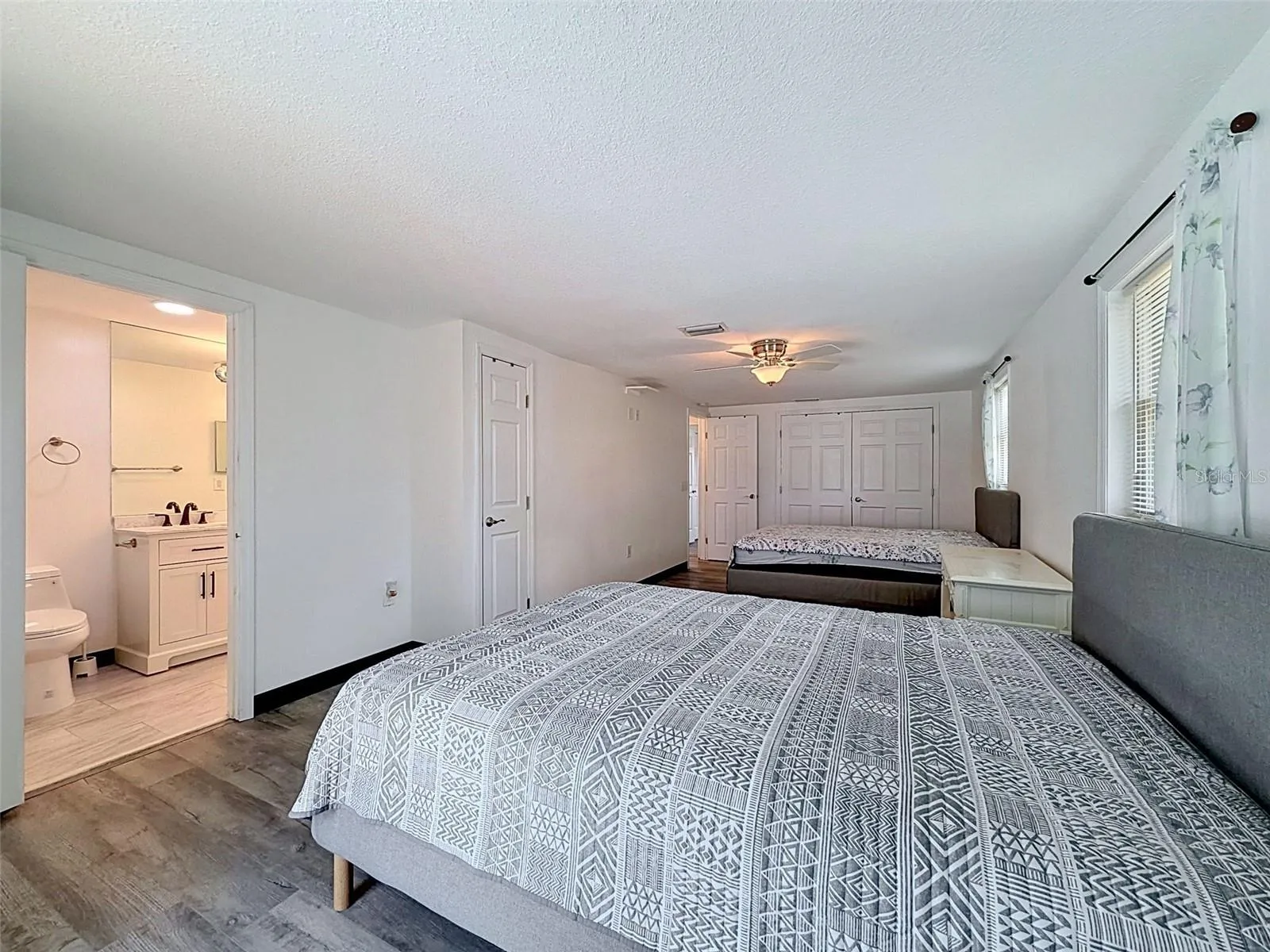 Large primary bedroom currently accommodates two queen beds.