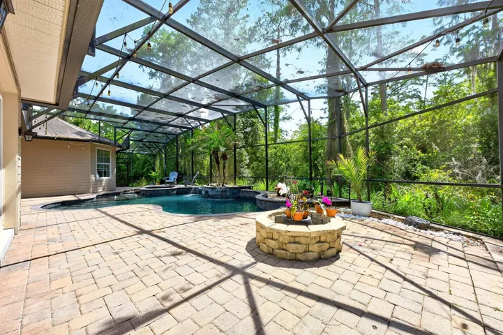 Screened pool, paver deck and a built-in fire pit to relax and unwind poolside.
