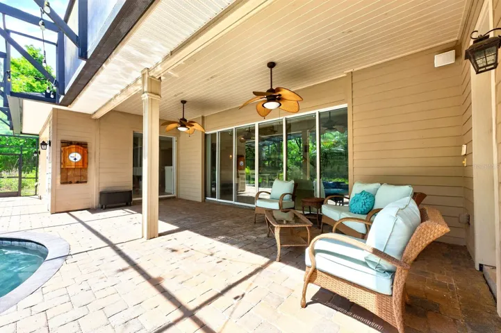 A wall of sliding glass doors opens the living room up to the covered lanai and screened pool.