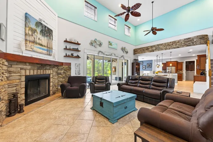 Living room features a wood burning fireplace and soaring ceilings.