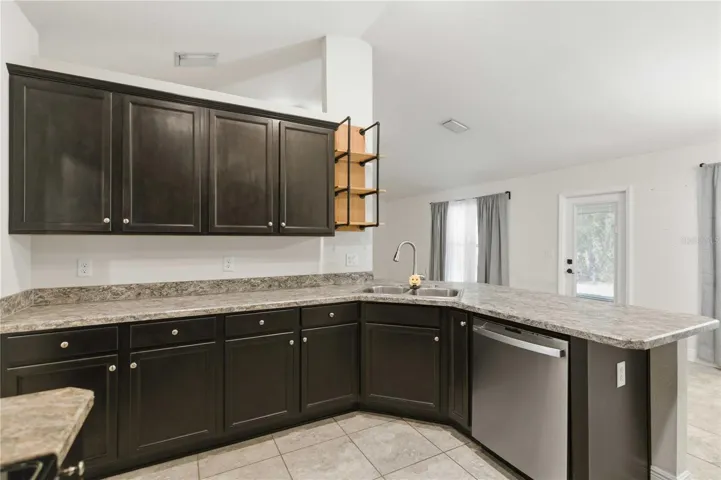 KITCHEN OVERLOOKS NOOK TO SCREENED LANAI THROUGH FRENCH DOOR