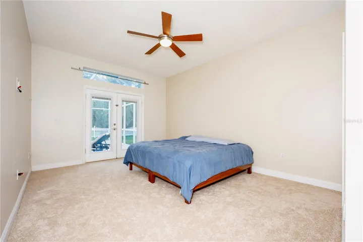 French doors leading to pool deck from primary bedroom