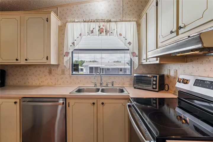 KITCHEN  WITH A GOOD VIEW FROM THE WINDOW, NEW DISHWASHER AND SMOOTH TOP STOVE.