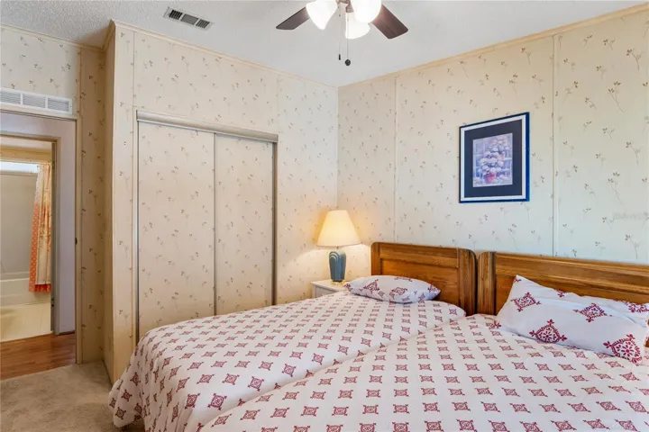 2ND BEDROOM WITH TWIN BEDS AND CEILING FAN/LIGHT, SMALLER CLOSET.