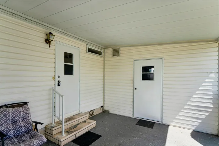 BACK DOOR, 2 STEPS TO GO INTO THE LAUNDRY ROOM, SHED DOOR, CHAIRS TO ENJOY OPEN PORCH