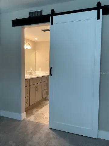 Barn door style entrance into primary bathroom