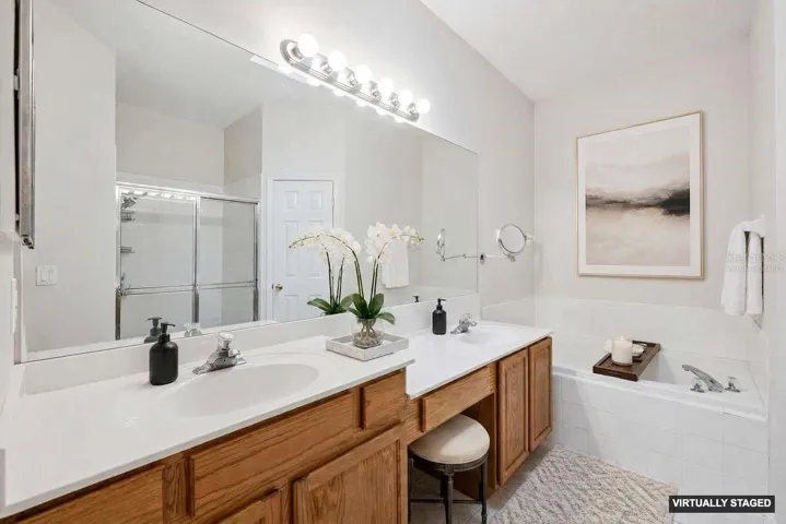 *Virtually staged* Primary bath with dual vanities and a makeup area plus a tub and separate shower