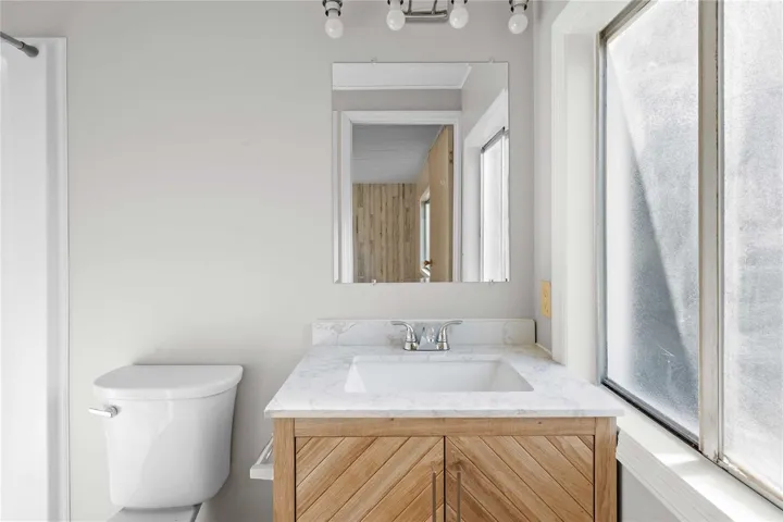 Updated primary bathroom with new step-in shower and vanity.
