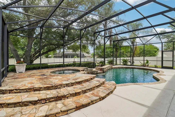 POOL AND SPA W/ DECORATIVE STONE TERRACE AND WATERFALL