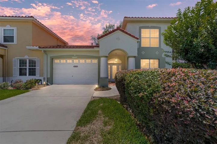 Twilight Exterior View – Front exterior of this two-story villa showcases Mediterranean-inspired architecture, a tiled roof, and a welcoming covered entry highlighted by soft evening lighting. Manicured landscaping and an extended driveway add to the home’s polished curb appeal.