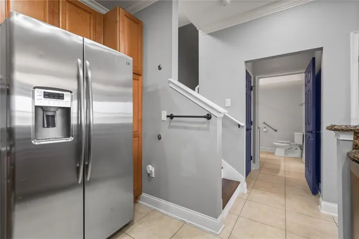 Kitchen with all stainless steel appliances looking into guest half bath.