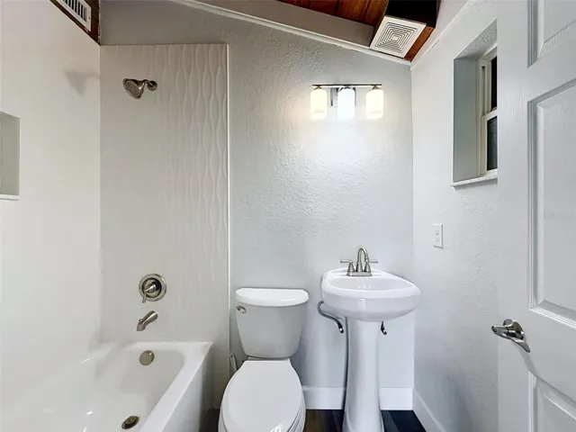 • Updated ensuite bathroom with modern tile finishes and clean coastal styling.