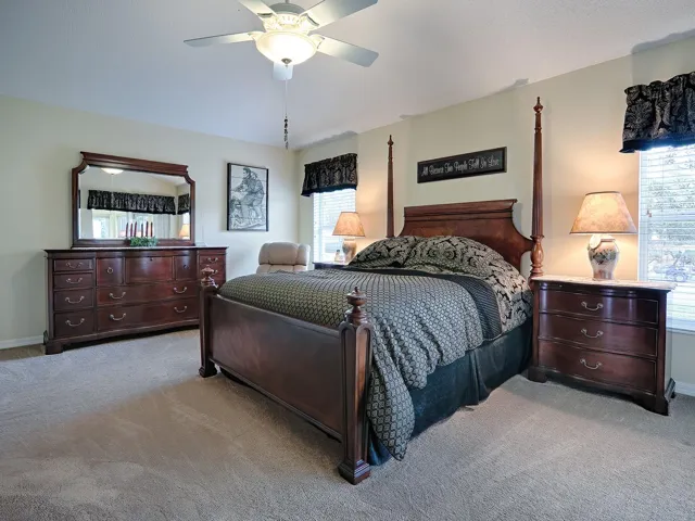 SPACIOUS PRIMARY BEDROOM WITH VAULTED CEILING, CARPET FLOORING, DUAL CLOSETS, AND EN SUITE PRIMARY BATHROOM.