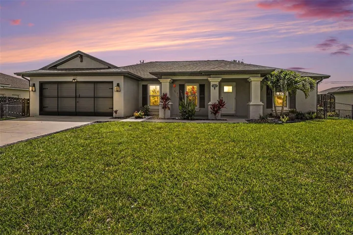 Contemporary stucco exterior with a covered front entry, decorative columns, and a two-car garage