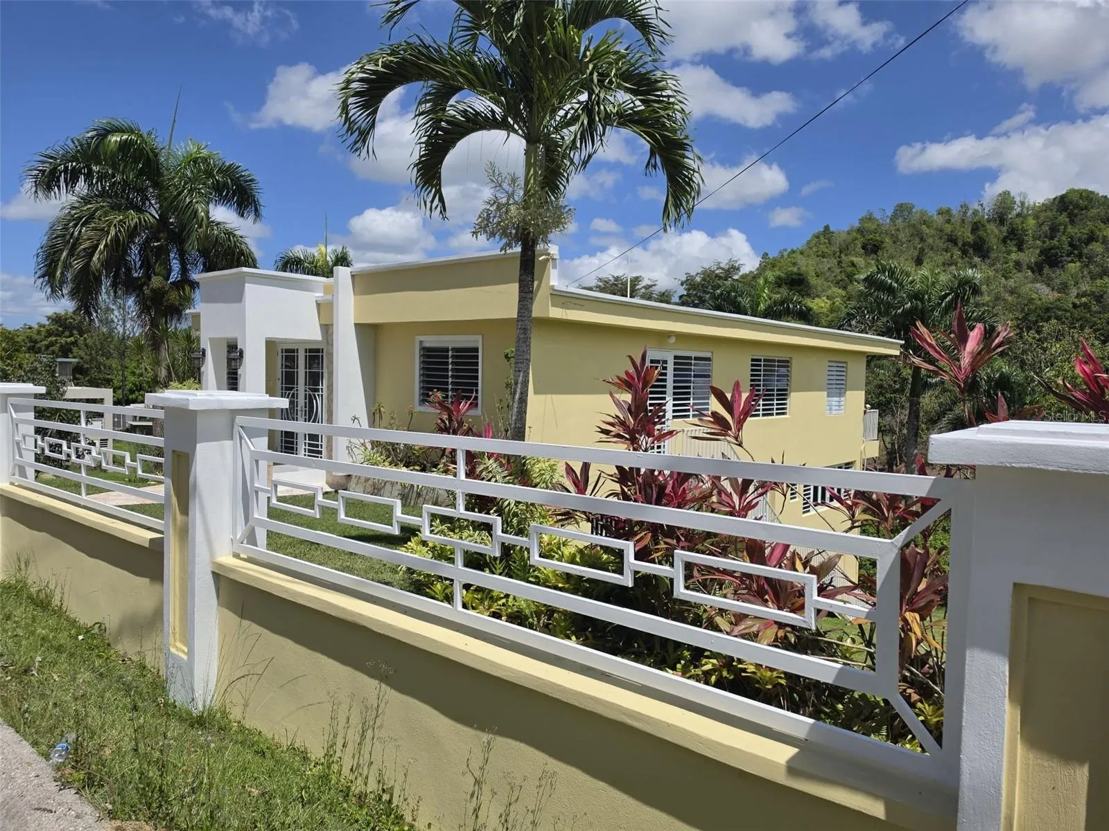 Hacienda del Dorado, Dorado, Puerto Rico property offering 4 bedrooms, 2.5 bathrooms, 2,500 sq. ft. of living space on a 3,947 sq. meter lot. Gated community with 24-hour security and excellent access to main roads in Dorado. Spacious layout with double carport for 4 vehicles and lower-level areas with plumbing and electrical ready for future conversion. Large lot provides privacy and expansion potential in a prime Dorado residential location.