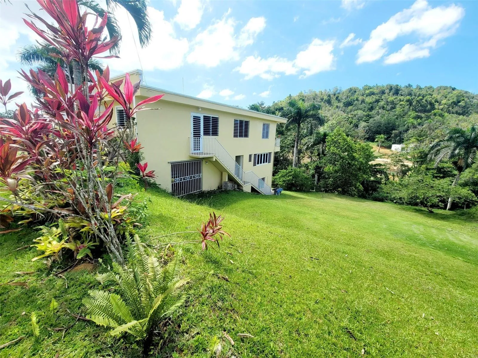 Hacienda del Dorado, Dorado, Puerto Rico property offering 4 bedrooms, 2.5 bathrooms, 2,500 sq. ft. of living space on a 3,947 sq. meter lot. Gated community with 24-hour security and excellent access to main roads in Dorado. Spacious layout with double carport for 4 vehicles and lower-level areas with plumbing and electrical ready for future conversion. Large lot provides privacy and expansion potential in a prime Dorado residential location.