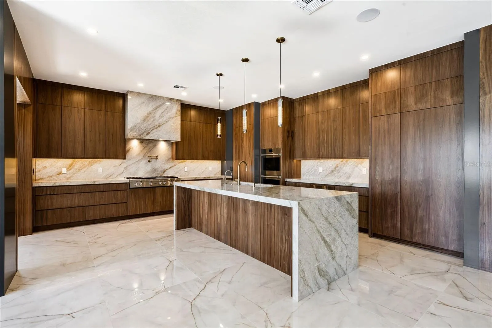 Kitchen has customised walnut cabinets and Taj Mahal counters