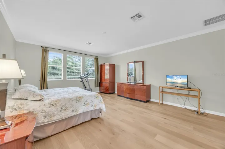 Primary bedroom with engineered hardwood flooring