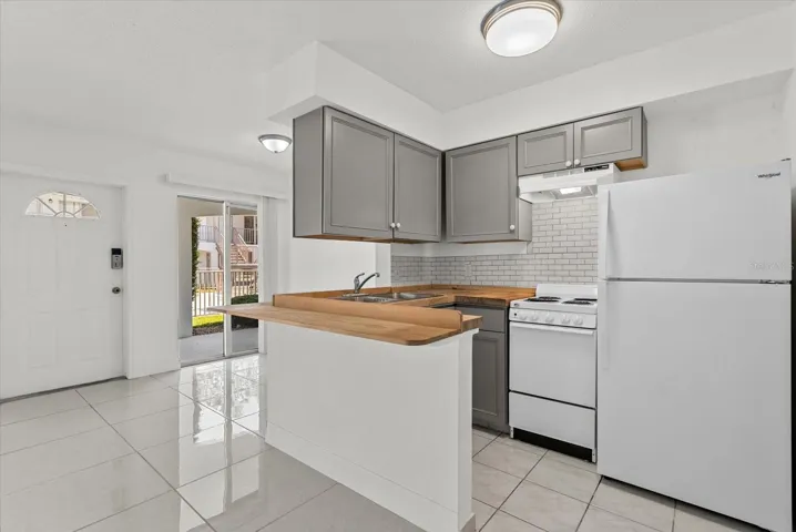 Kitchen features updated cabinetry, range & refrigerator