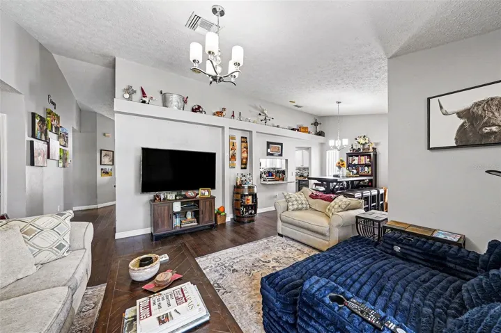 Living room with dining room space, bar to the kitchen, and sunroom