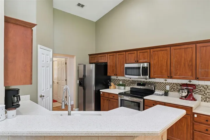 Sleek stainless steel appliances, premium wood cabinetry, and an extended counter space make this Oviedo kitchen as functional as it is inviting.