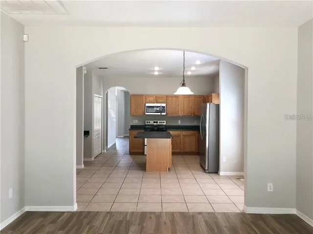 Large arch way  in the family  room with view looking back from the back of the house towards the kitchen