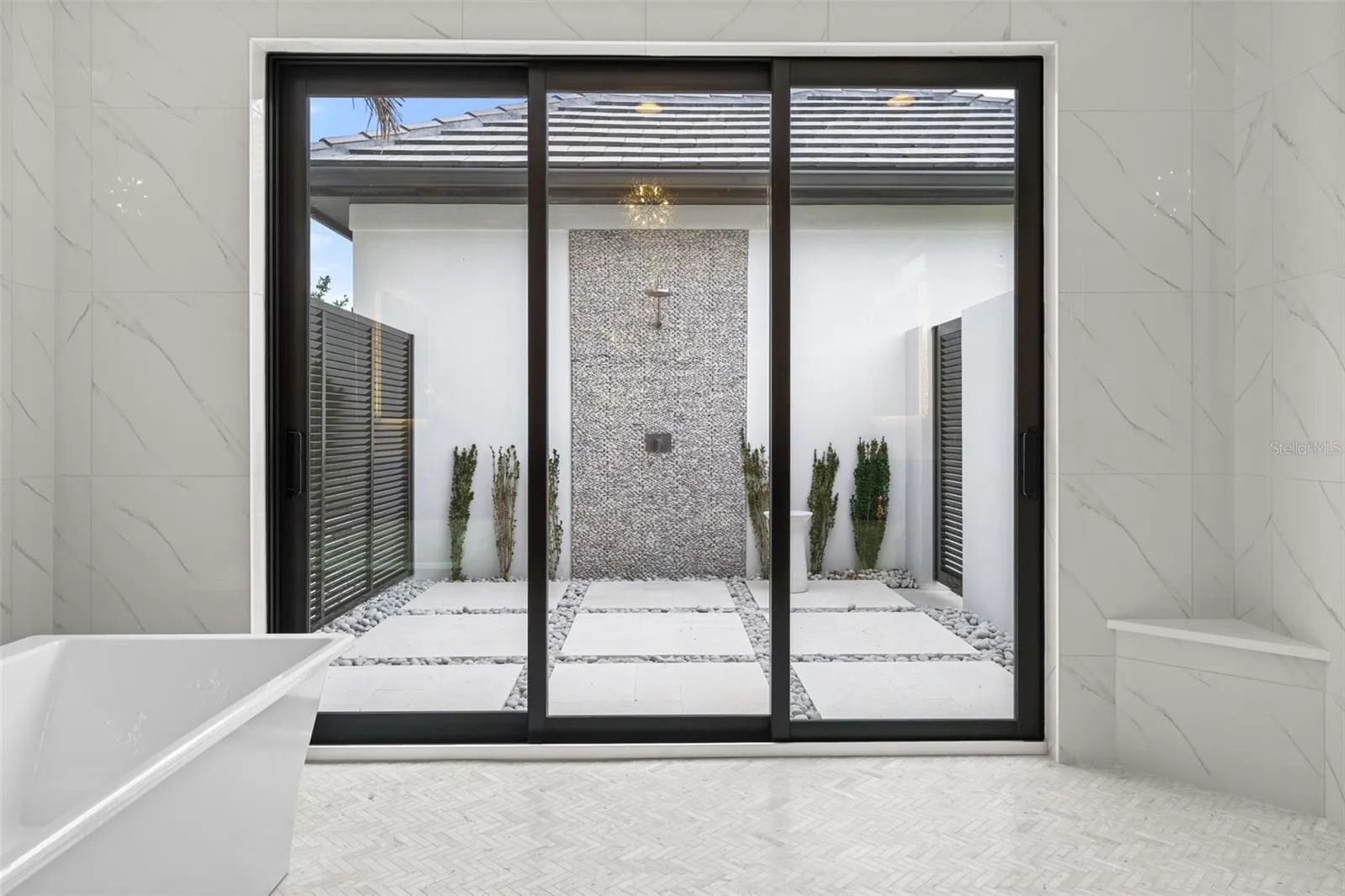 The sliding glass doors lead to the outdoor shower and private patio.