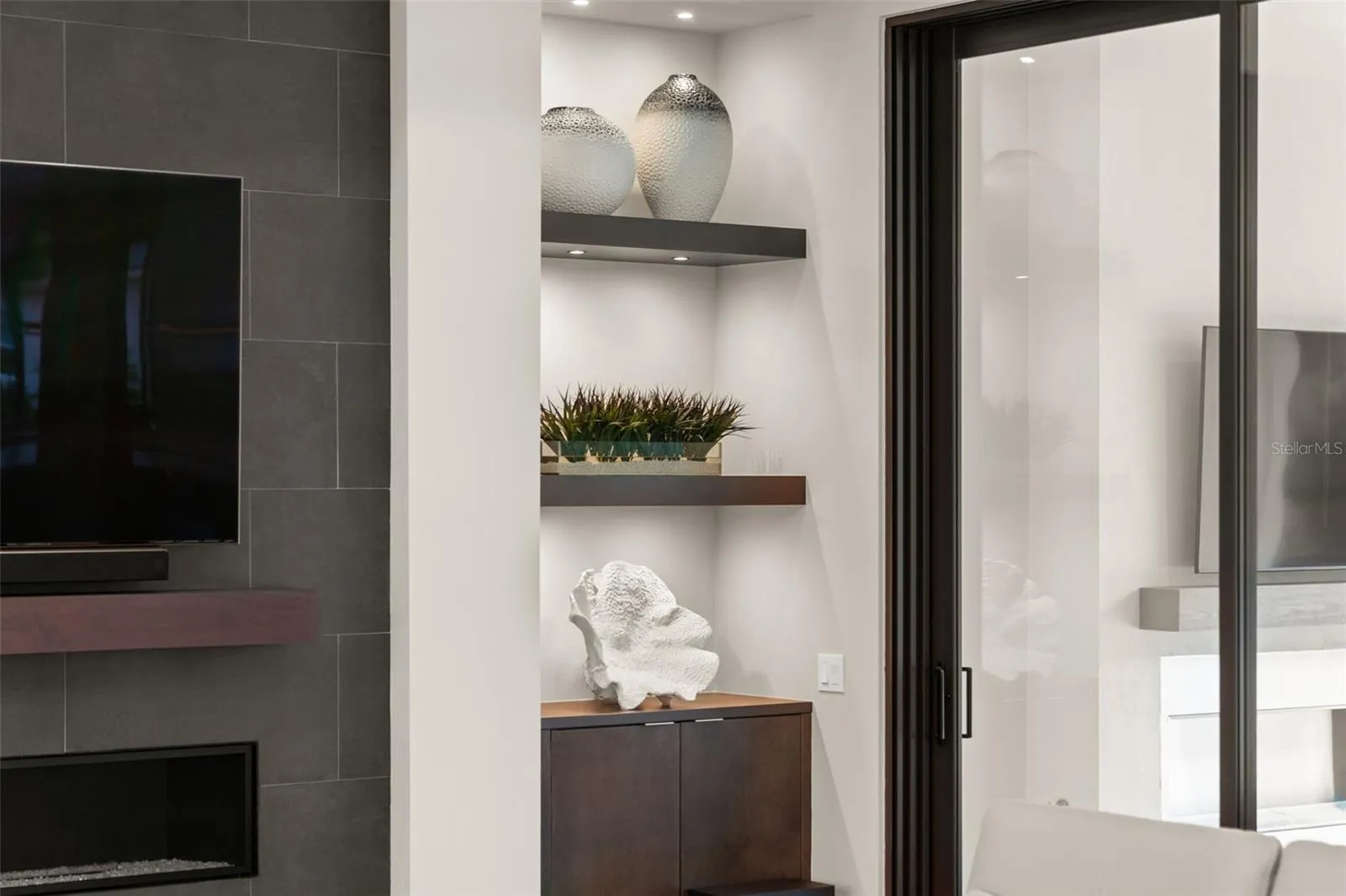 The custom built-in cabinetry and shelving has accent lighting.