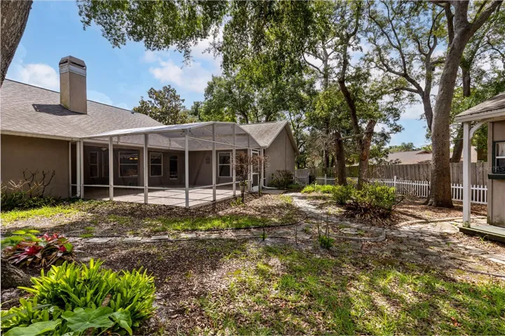 Backyard is enclosed with a white vinyl picket fence