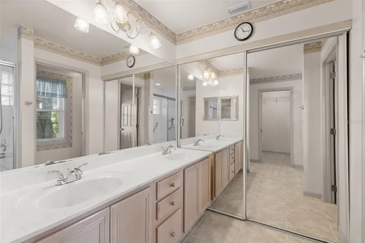 Primary ensuite bath with dual sinks and second closet