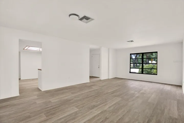 Spacious main living area featuring great natural light and modern luxury vinyl flooring.