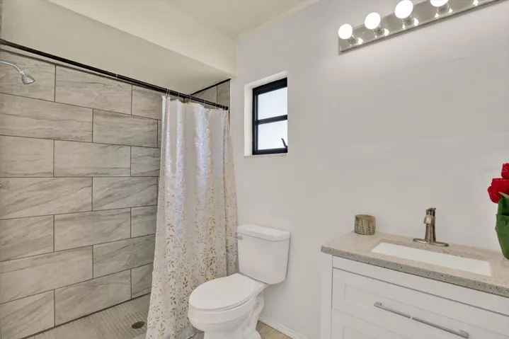 Modern primary en-suite bathroom featuring a stylish single vanity and a beautifully tiled walk in shower.