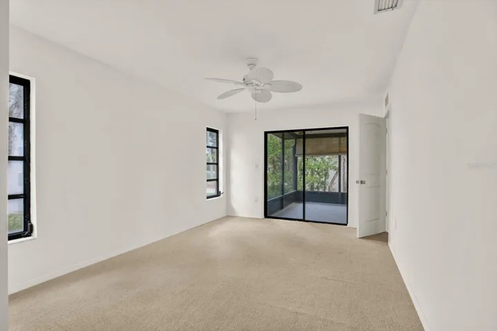 Primary bedroom offering  direct access to the private, screened in lanai through sliding glass doors.