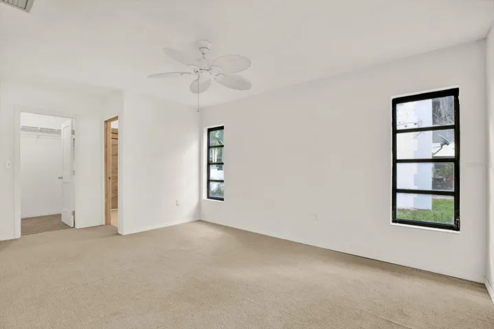 Spacious primary suite featuring bright natural light, a private bathroom and a large walk in closet.