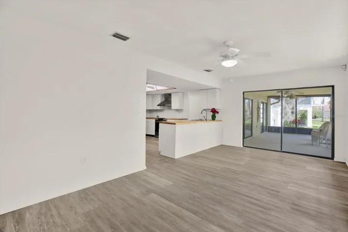 Bright open concept living area with seamless flow to the kitchen and screened lanai.